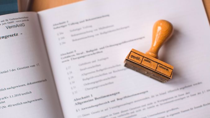 Drveni pečat položen na otvoren nemački pravni dokument